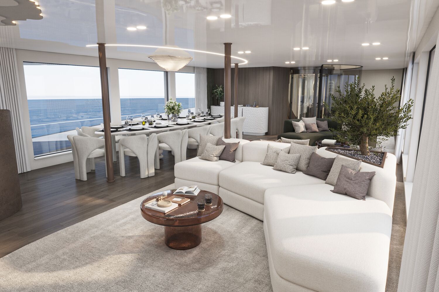 Modern open-plan living and dining area with large windows overlooking the ocean, featuring a white sectional sofa, round coffee table, dining table with white chairs, potted plant, and neutral, elegant decor.