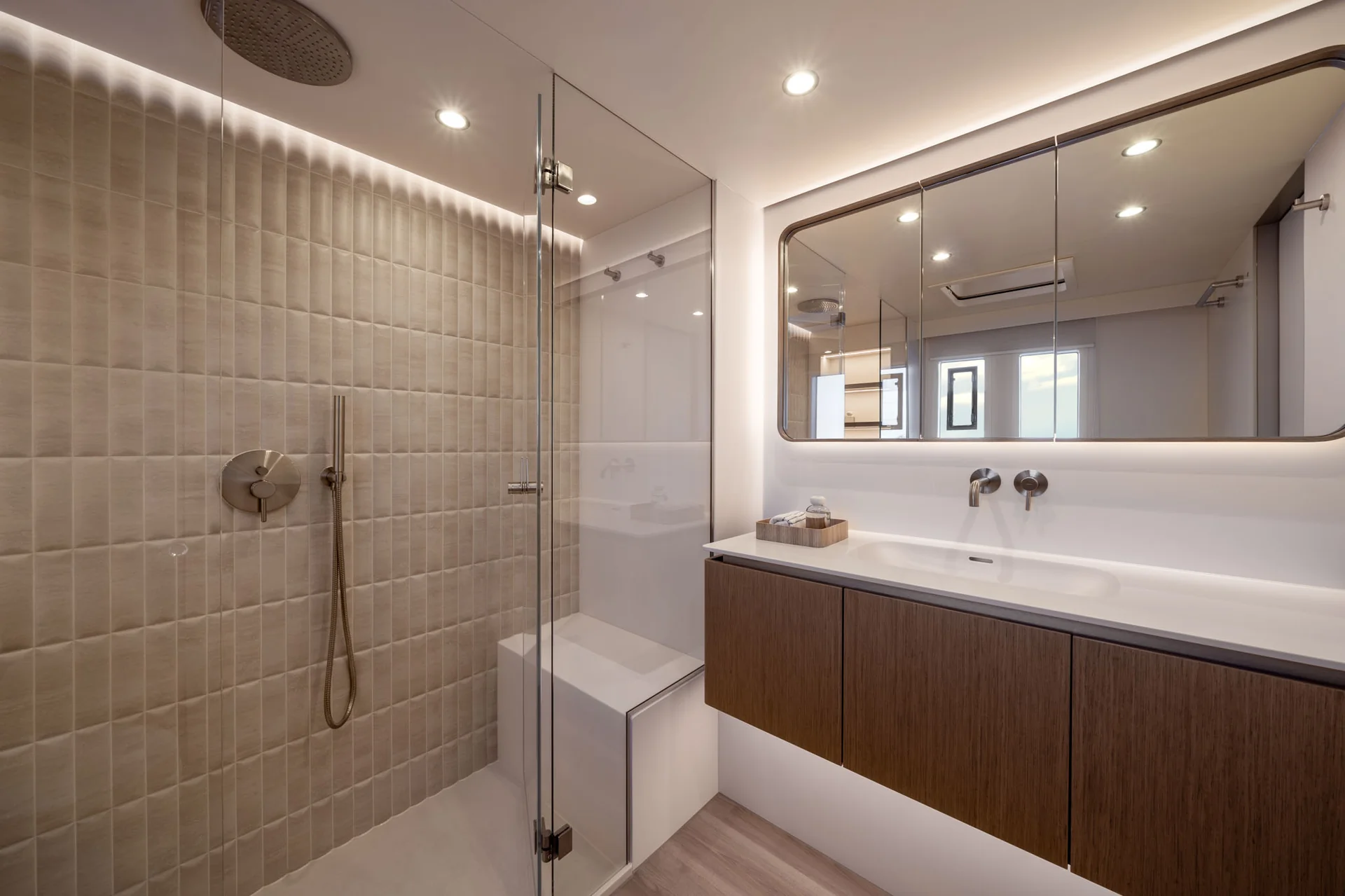 A modern bathroom featuring a glass-enclosed shower with a built-in bench next to a floating vanity with a mirror and integrated lighting.