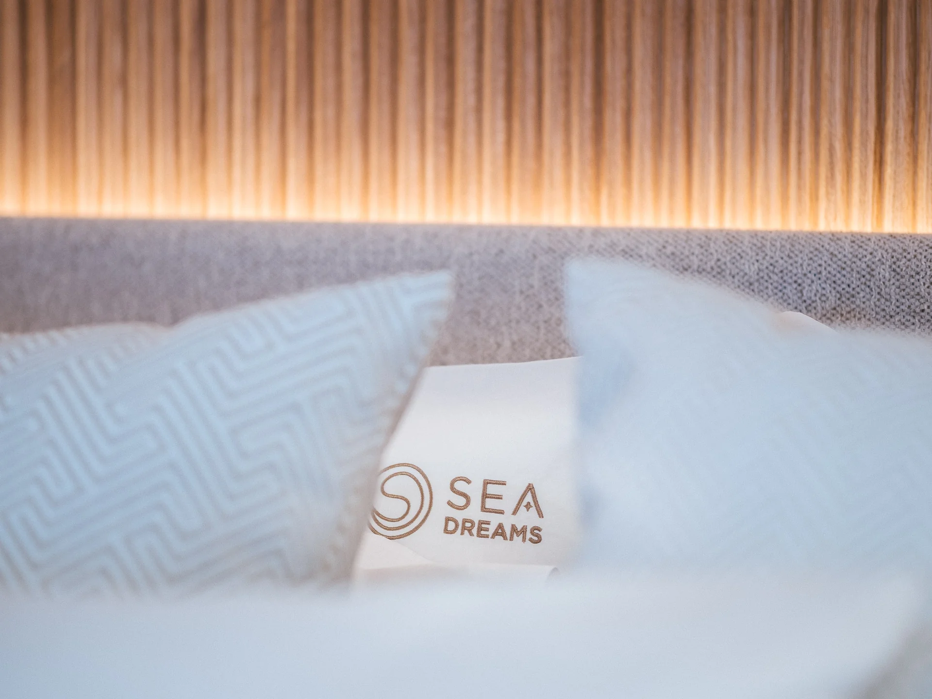A pillow embroidered with the Sea Dreams logo and text.